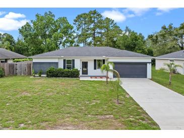 Charming single-story home features a well-manicured lawn, attached garage, and fresh landscaping at 2626 Coachman Dr, Deltona, FL 32738