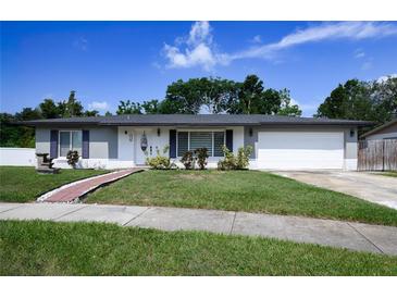 Charming single-story home with a well-manicured lawn and a welcoming brick pathway at 874 Brevard Ct, Orlando, FL 32822