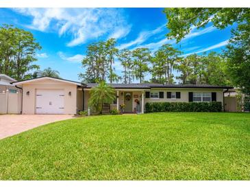 Charming single-story home with a lush green lawn and attached garage at 1018 Turner Rd, Winter Park, FL 32789