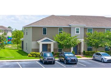 Inviting two-story townhome with neutral siding, landscaped grounds, and convenient parking at 130 Claire Ln, Davenport, FL 33837