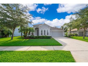 Charming single-Gathering home with well-manicured lawn, mature trees, and a two-car garage at 1415 Ellis Fallon Loop, Oviedo, FL 32765