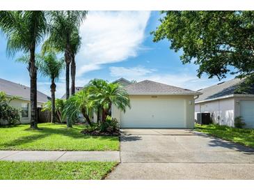 Charming single-Gathering home with a two-car garage, well-maintained landscaping, and beautiful palm trees in the front yard at 14224 Colonial Lakes Dr, Orlando, FL 32826