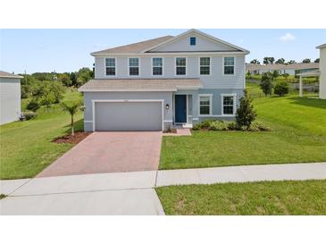 Charming two-story home with a brick driveway and well-manicured lawn offers a welcoming curb appeal at 2168 Aibonito Cir, Clermont, FL 34711