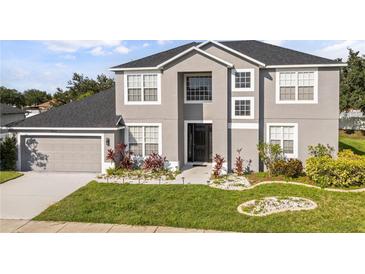 Charming two-story home with landscaped yard, black roof, neutral paint and two car garage at 3824 Blue Dasher Dr, Kissimmee, FL 34744