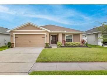 Charming single-story home featuring a well-manicured lawn, neutral color palette, and attached two-car garage at 5416 Tessin Trl, St Cloud, FL 34771