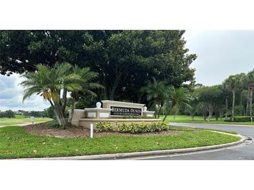 Entrance sign for Bermuda Dunes Luxury Condominiums surrounded by palm trees and lush landscaping at 7350 Westpointe Blvd # 234, Orlando, FL 32835