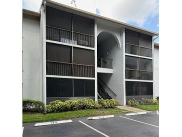 Exterior view of building with screened in patios, parking, and landscaped bushes at 8211 Sun Spring Cir # 11, Orlando, FL 32825