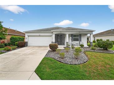 Charming single-story home boasts a manicured lawn and an inviting front porch with a two-car garage at 8336 Sw 77Th Ct, Ocala, FL 34476