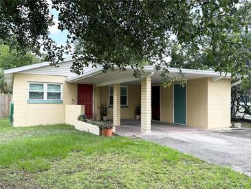 Charming single-story home featuring a covered carport, well-maintained lawn, and mature trees at 1400 Yates St, Orlando, FL 32804