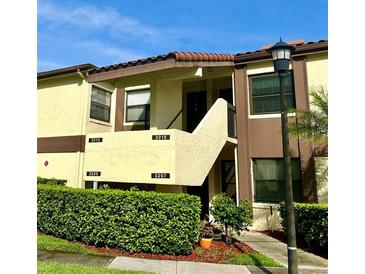 Inviting two-story condo building with lush landscaping and visible unit numbers at 3207 Westridge Blvd # 104, Orlando, FL 32822