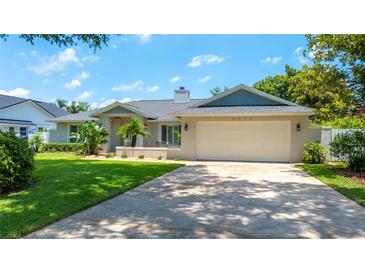 Charming single-story home with well-maintained landscaping and a two-car garage on a sunny day at 8473 Granada Blvd, Orlando, FL 32836