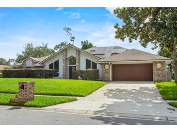 Charming single-story home with a well-manicured lawn, solar panels, and an attached two-car garage at 9774 Bohart Ct, Orlando, FL 32836