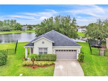 Charming single-story home with a well-maintained front yard and a view of the serene lake at 10836 Tilston Pt, Orlando, FL 32832
