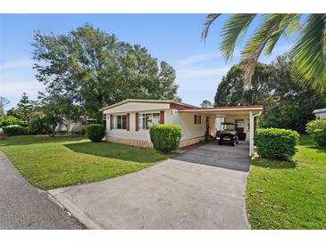 Well-maintained home featuring a carport, manicured lawn, and mature landscaping, offering great curb appeal at 2060 Lamplight Cir, Mount Dora, FL 32757