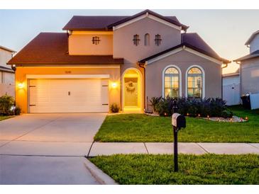 Charming two-story home featuring an attached garage, arched windows, and well-maintained landscaping at 5018 Tupelo Ct, Minneola, FL 34715
