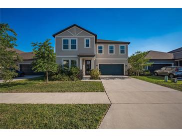 Charming two-story home with well-maintained lawn, lush landscaping, and a driveway leading to a two-car garage at 9199 Waverly Walk Dr, Orlando, FL 32817