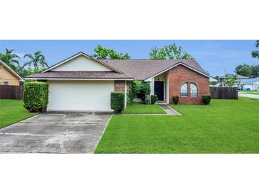 Charming single-story home with a brick facade, well-manicured lawn, and an attached two-car garage at 9833 Tattersall Ave, Orlando, FL 32817