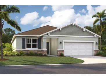 Inviting single-Gathering home featuring a two-car garage, stone accents, and lush landscaping at 1207 Normandy Dr, Haines City, FL 33844