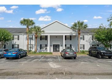 The property boasts a well-maintained exterior with a light gray brick facade and lush landscaping at 225 Lewfield Cir # 225, Winter Park, FL 32792