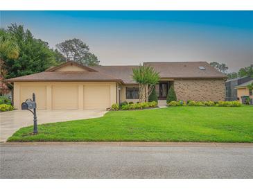 Charming single-story home featuring a three-car garage and lush, green lawn at 6766 Edgeworth Dr, Orlando, FL 32819