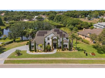 Stately two-story home featuring solar panels, lush landscaping, and a well-manicured lawn at 8131 Vineland Oaks Blvd, Orlando, FL 32835