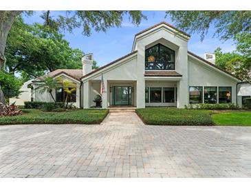Stunning two-story home boasting a brick driveway, lush landscaping and charming architectural details at 9743 Chestnut Ridge Dr, Windermere, FL 34786