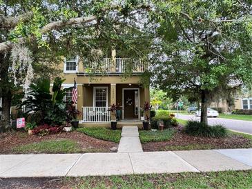 Charming two-story home with a front porch, balcony and lush landscaping creating a welcoming curb appeal at 10350 Lake District Ln # S, Orlando, FL 32832