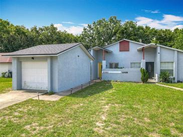 Charming home featuring a spacious front yard, attached garage, and well-maintained landscaping at 10460 Riva Ridge Trl, Orlando, FL 32817