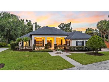 Beautiful single story home featuring manicured lawn, mature landscaping, and architectural details at 1141 Waldorf Ct, Winter Springs, FL 32708