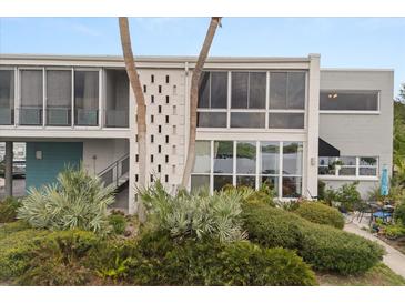 Modern condo featuring a unique facade with lush landscaping, a blue door and decorative concrete block at 151 N Orlando Ave # 212, Winter Park, FL 32789