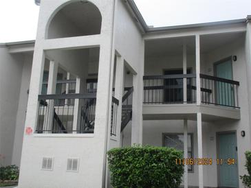 Exterior view of a condo building showcasing balconies, neutral paint, and architectural details at 2002 Cascades Blvd # 201, Kissimmee, FL 34741