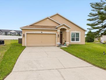 Charming single-story home featuring a two-car garage, well-manicured lawn and inviting curb appeal at 204 Cotswold Cir, Davenport, FL 33837