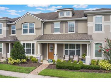 Charming two-story home with a covered front porch, well-maintained landscaping, and neutral-toned exterior at 2696 Giardino Loop, Kissimmee, FL 34741