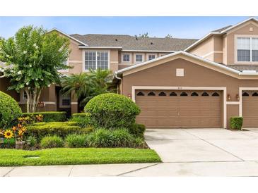 Inviting two-story townhome with a neatly maintained lawn, complemented by a two-car garage and neutral color palette at 449 Cruz Bay Cir, Winter Springs, FL 32708