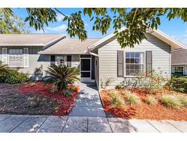 Charming home featuring manicured landscaping, stone walkway, and a screened-in front porch at 1126 Villa Ln # 91, Apopka, FL 32712