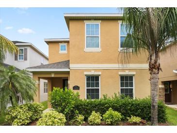 Charming two-story home with a well-manicured lawn and lush tropical landscaping at 15208 Avenue Of The Arbors, Winter Garden, FL 34787