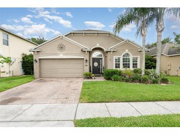 Charming single-story home boasts manicured lawn, mature landscaping, and a brick-paved driveway at 15606 Montesino Dr, Orlando, FL 32828