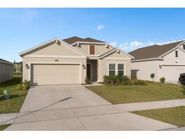 Charming single-story home with a well-maintained lawn, attached garage, and neutral color palette at 4223 Little Owl Ln, Kissimmee, FL 34746