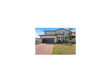 Charming two-story home with a brick driveway and attached two car garage at 5550 Sabal Dr, St Cloud, FL 34771