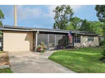 Single-story home featuring a screened porch, solar panels, landscaping, and an American flag displayed outside at 618 Acapulca Way, Altamonte Springs, FL 32714