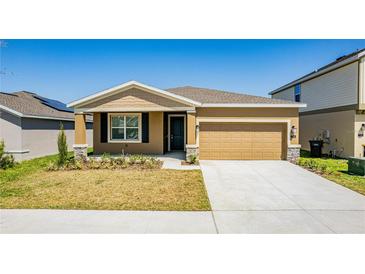 Charming single-story home with a well-maintained lawn and a two-car garage at 716 Daring Dr, Davenport, FL 33837