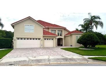 Charming home with a red tile roof, 3-car garage, and brick-paved driveway at 9062 Dancy Tree Ct, Orlando, FL 32836