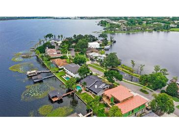 Stunning aerial view of waterfront homes and lush landscaping on a picturesque lake at 9146 Bay Point Dr, Orlando, FL 32819