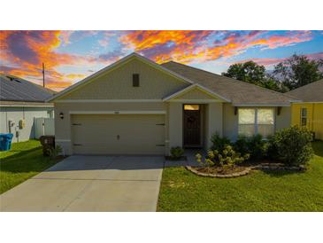 Charming single Gathering home with a two-car garage, lawn, and attractive landscaping at 984 Chanler Dr, Haines City, FL 33844
