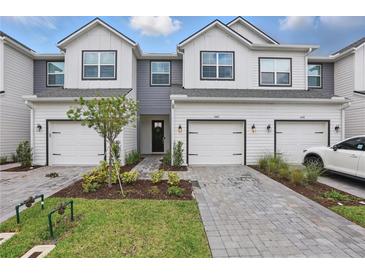 Charming townhomes featuring modern farmhouse design with white siding and well-manicured landscaping at 1462 Brookdale Ct, Oviedo, FL 32765