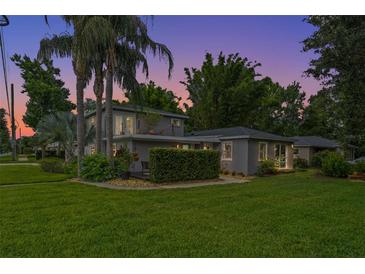 Well-maintained home with a lush lawn and tropical landscaping against a vibrant sunset at 1519 N Westmoreland Dr, Orlando, FL 32804