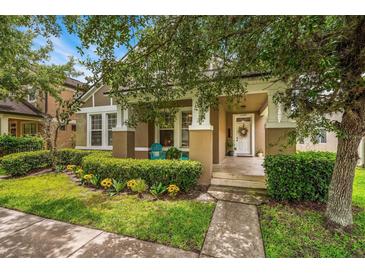 Charming home featuring a covered porch, lush landscaping, and a welcoming entrance with a white front door at 2246 Florida Soapberry Blvd, Orlando, FL 32828