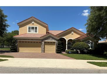Beautiful two-story home featuring a three-car garage and red-tiled roof in a well manicured yard at 2258 Rickover Pl, Winter Garden, FL 34787