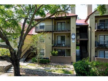 Condominium exterior showcasing balconies, a red roof, and verdant landscaping for inviting curb appeal at 234 Afton Sq # 305, Altamonte Springs, FL 32714