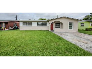 Charming single-story home featuring a red front door, well-maintained lawn, and inviting curb appeal at 26 Channing Ave, Orlando, FL 32811